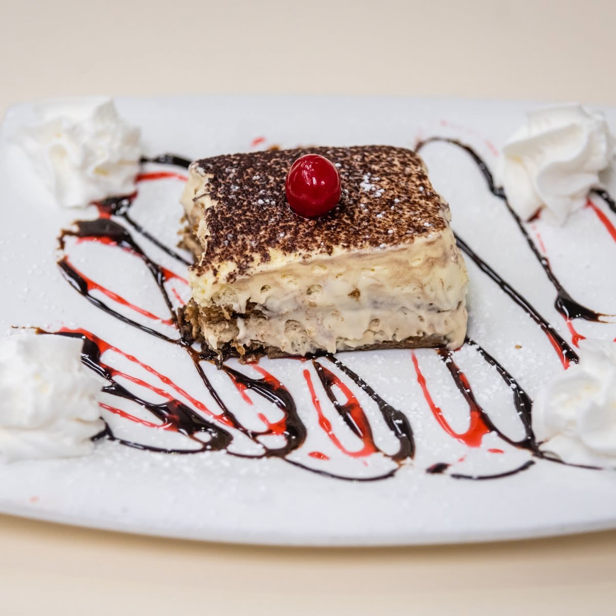 Tiramisu square dusted with cocoa and cherry