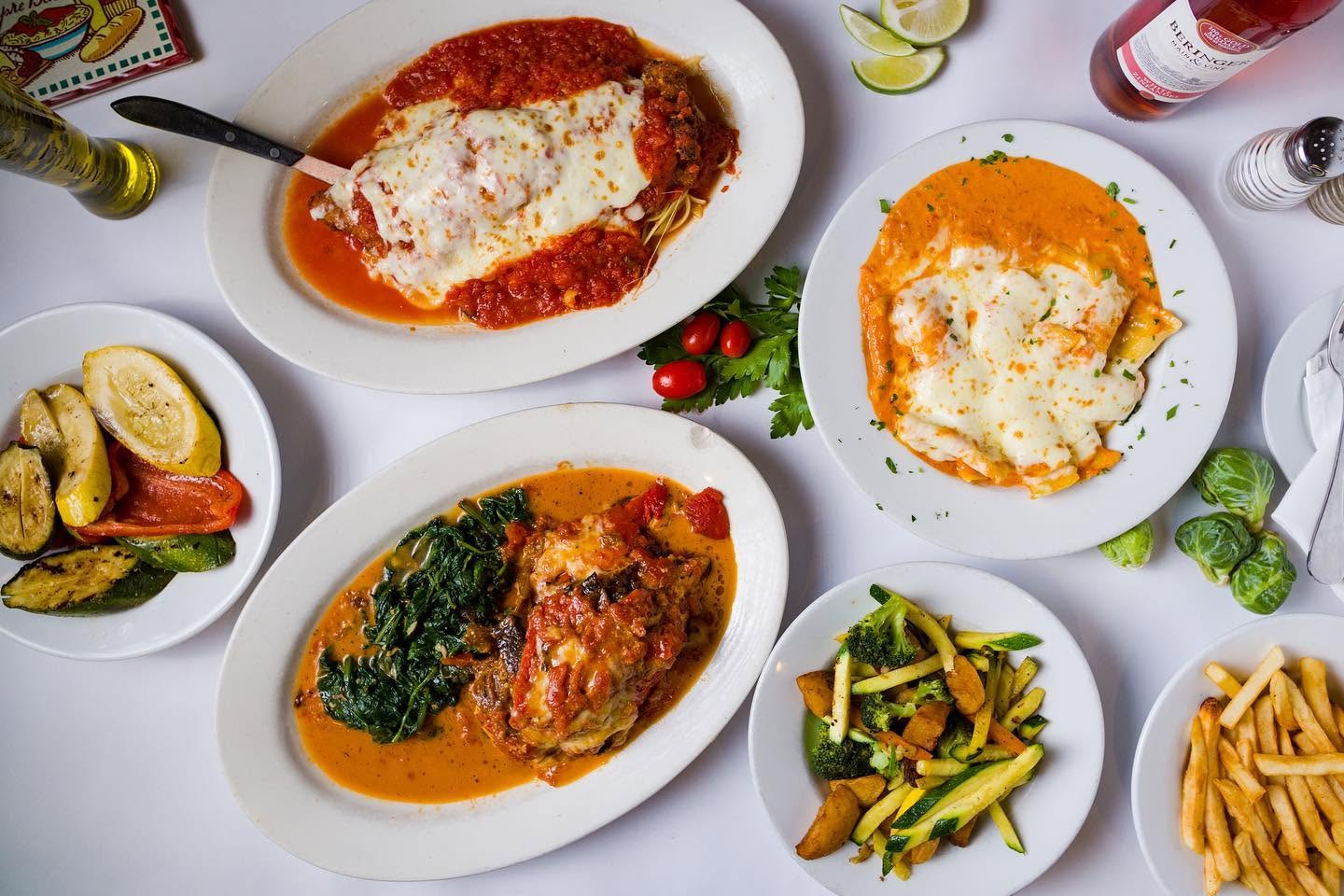 An overhead spread of Da Vinci's entrées — chicken parmigiana, baked pasta, and sautéed vegetables