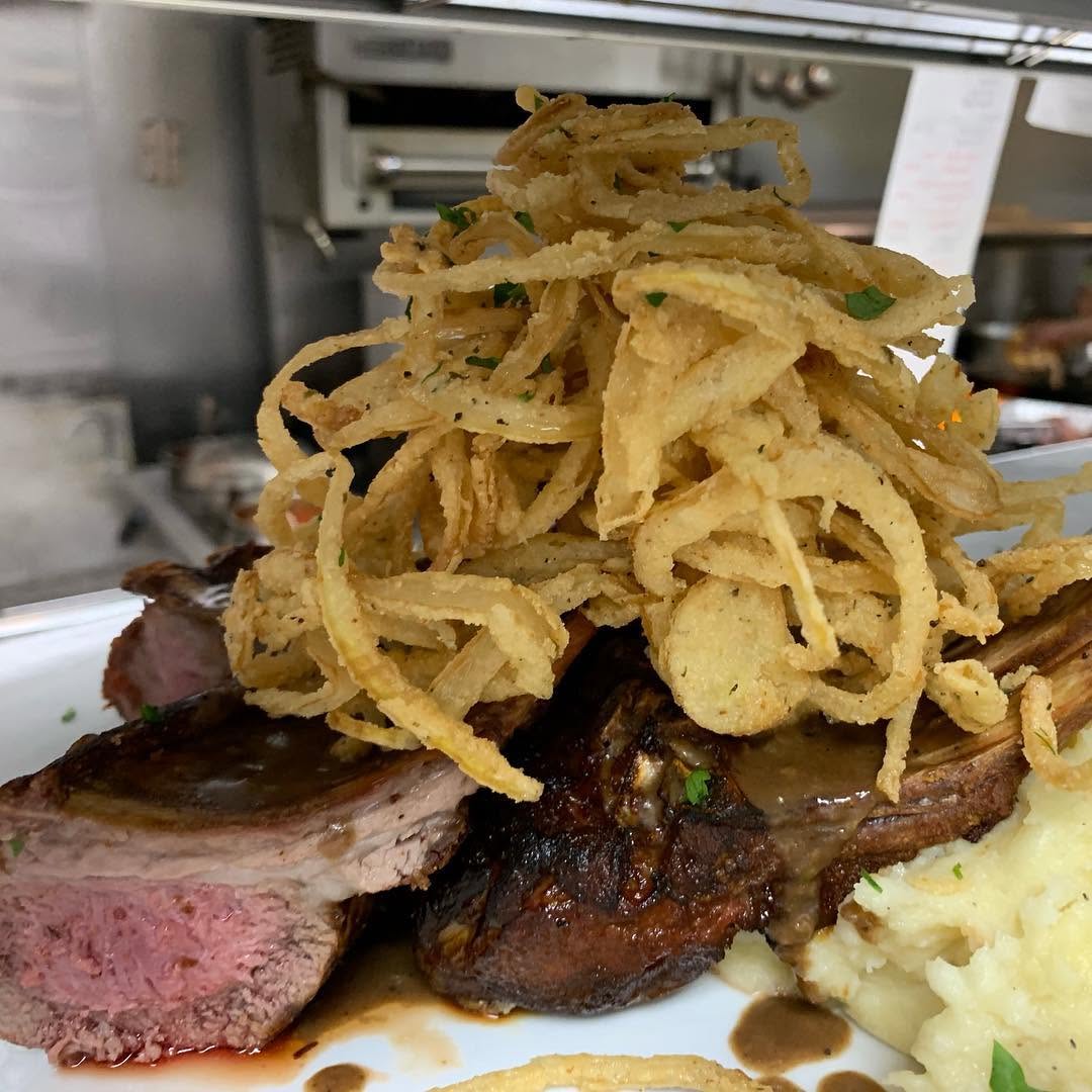 Sliced grilled steak topped with crispy fried onions