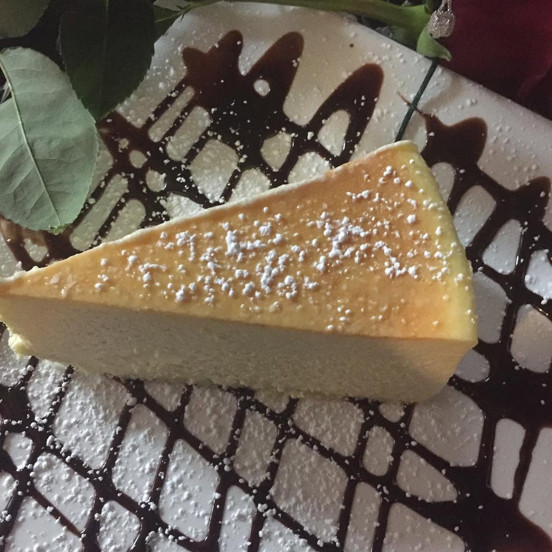 Slice of New York cheesecake with cocoa dusting