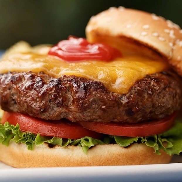 Cheeseburger with cheddar, ketchup, and tomato
