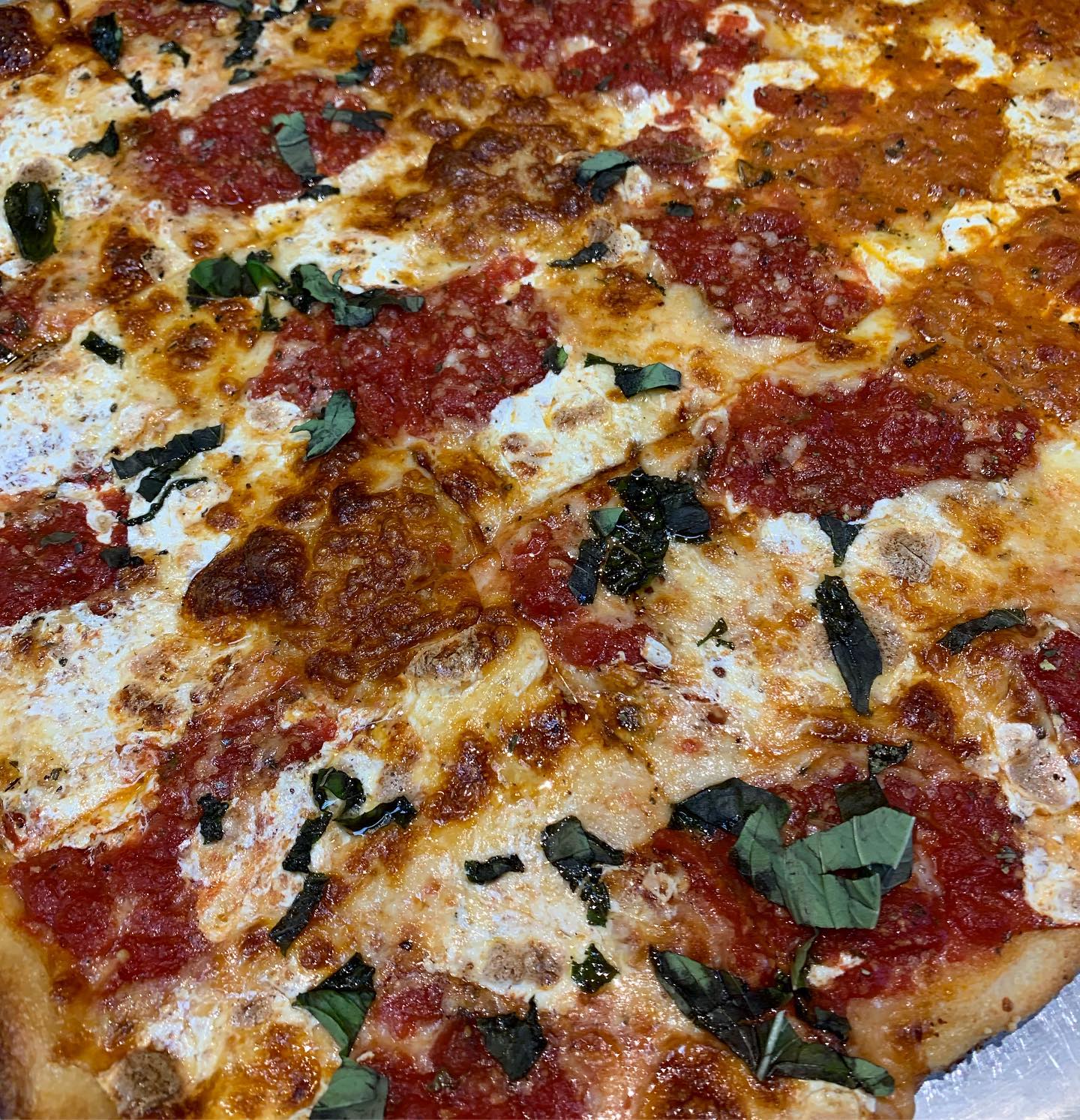 Round pepperoni pizza with mozzarella and fresh basil