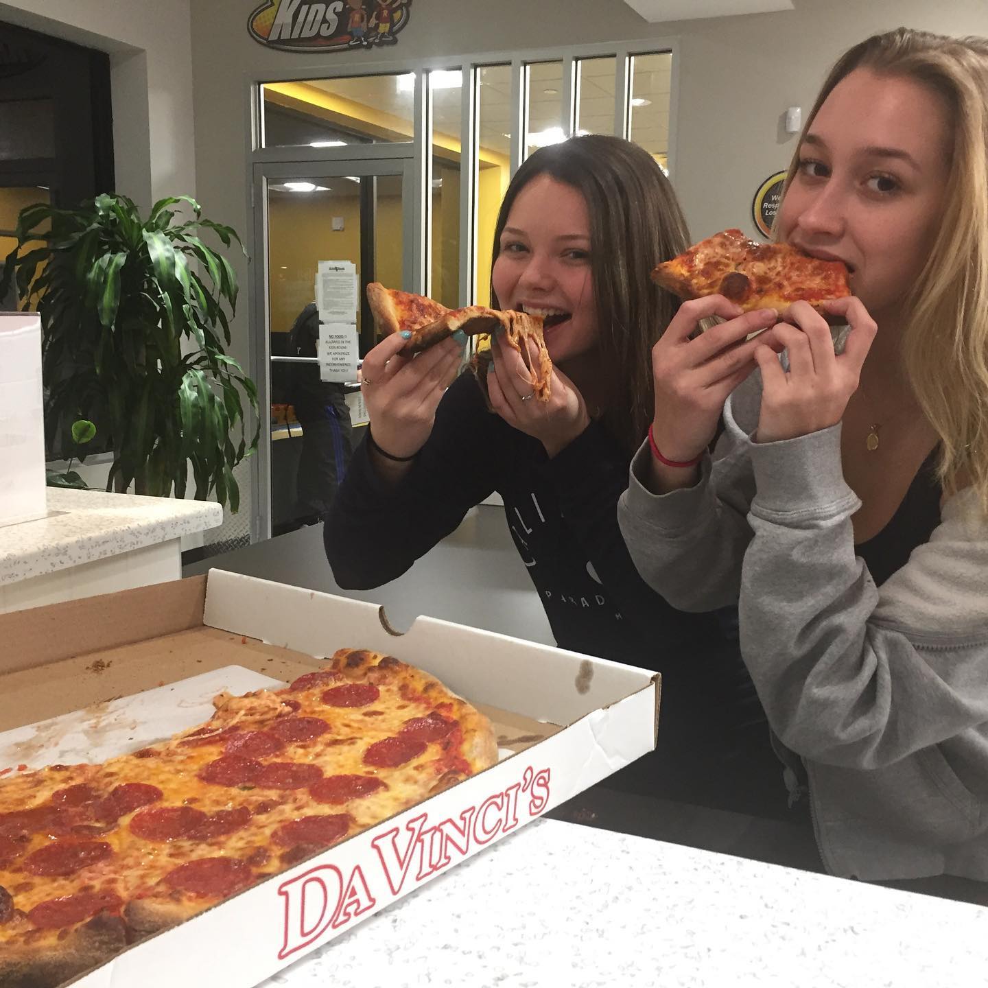 Customers eating pizza slices from a Da Vinci's box