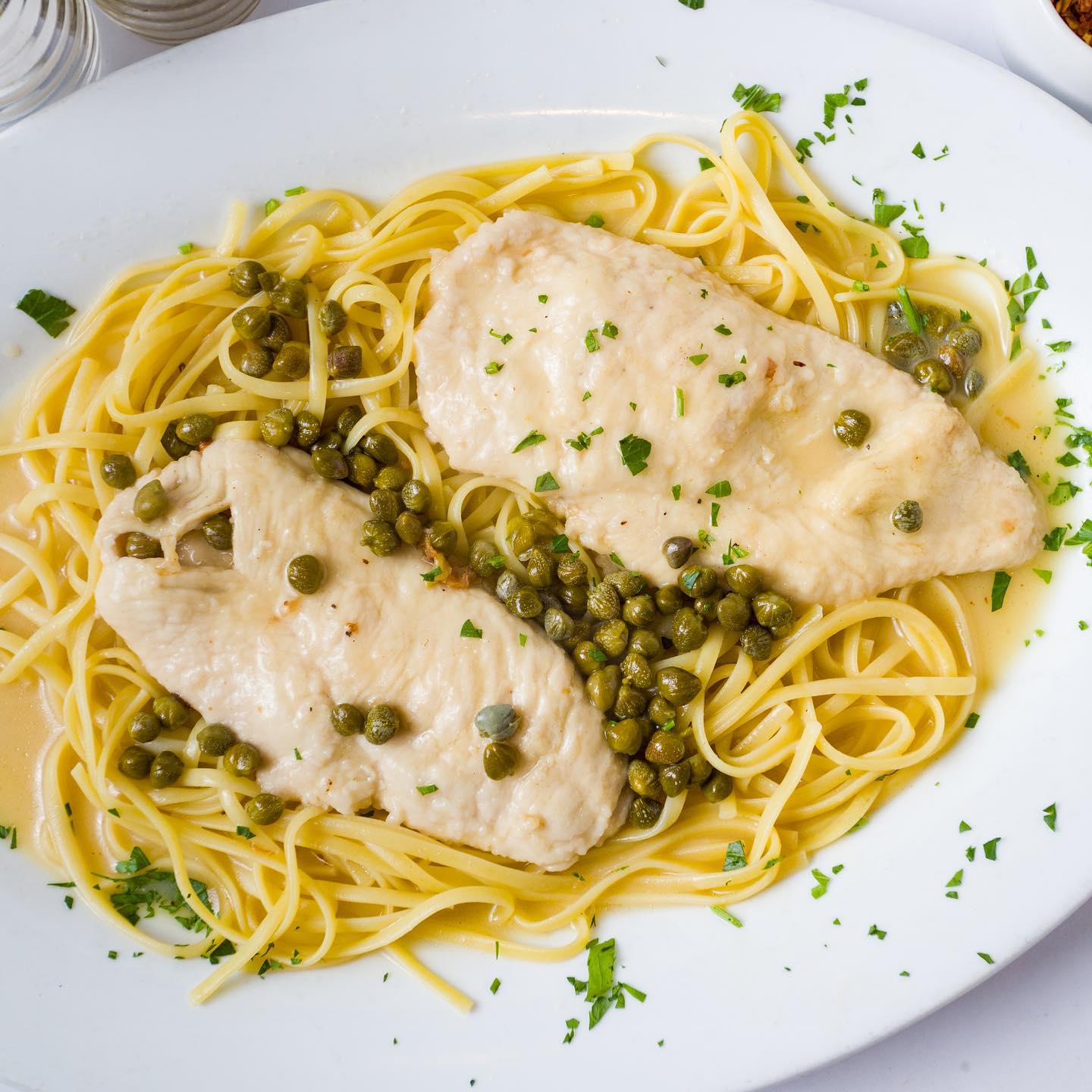Chicken francese with capers over linguine