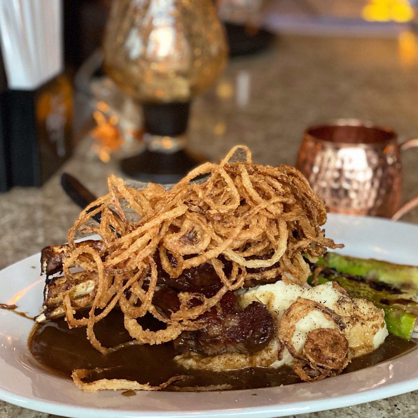 Braised short rib with crispy onion strings and mashed potatoes