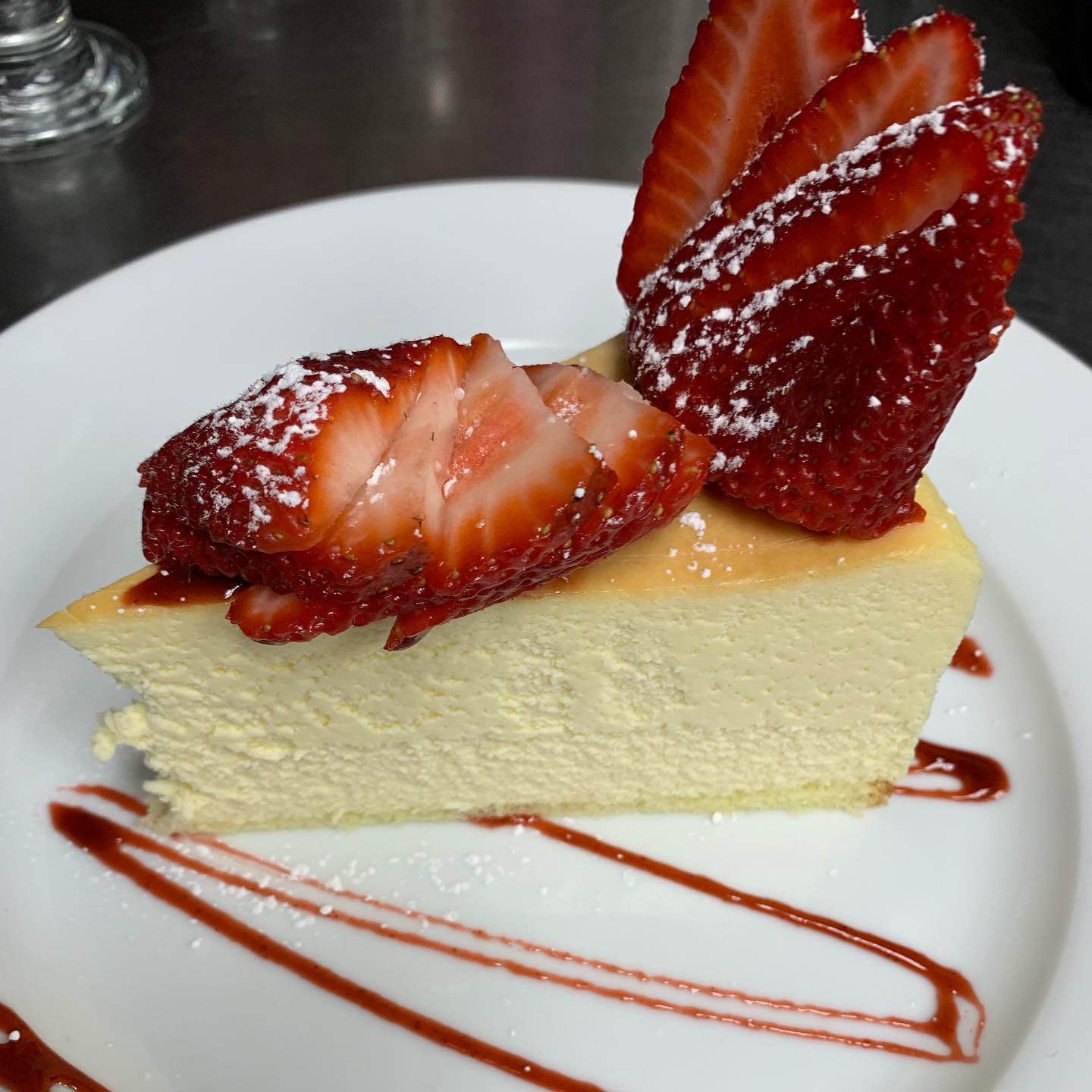 Cheesecake slice topped with fresh strawberries