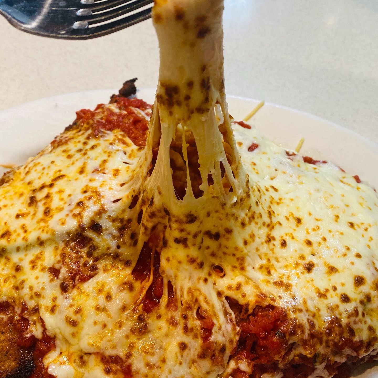 Cheese pull from a baked parmesan cutlet