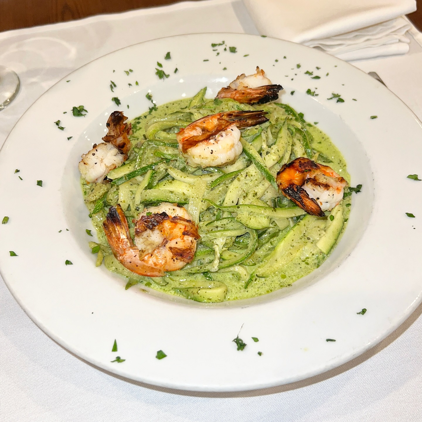 Grilled shrimp over zucchini noodles in pesto cream sauce