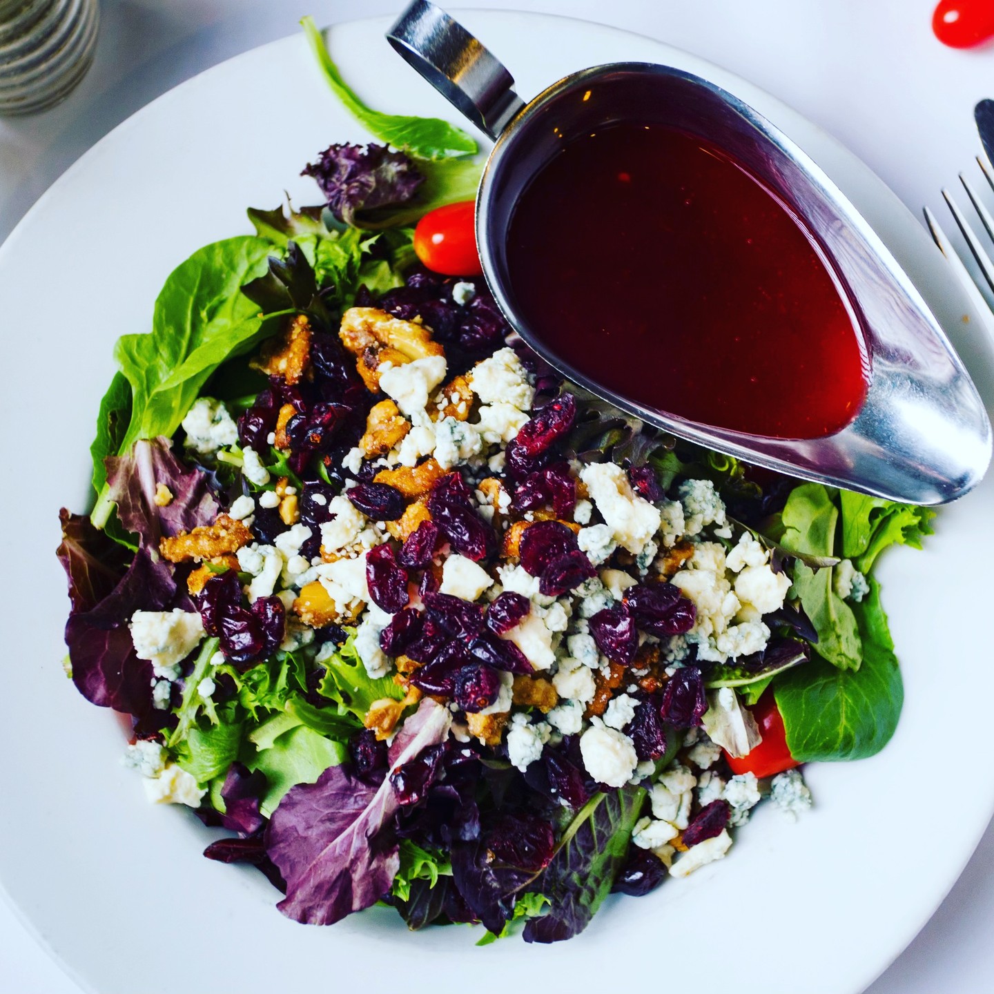 Mixed greens salad with cranberries, blue cheese, and walnuts