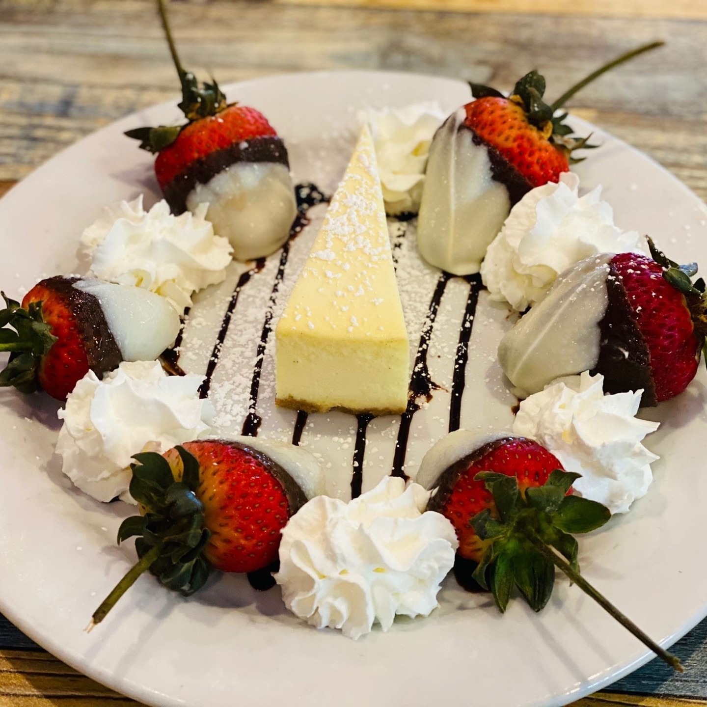 Cheesecake with chocolate-covered strawberries and whipped cream
