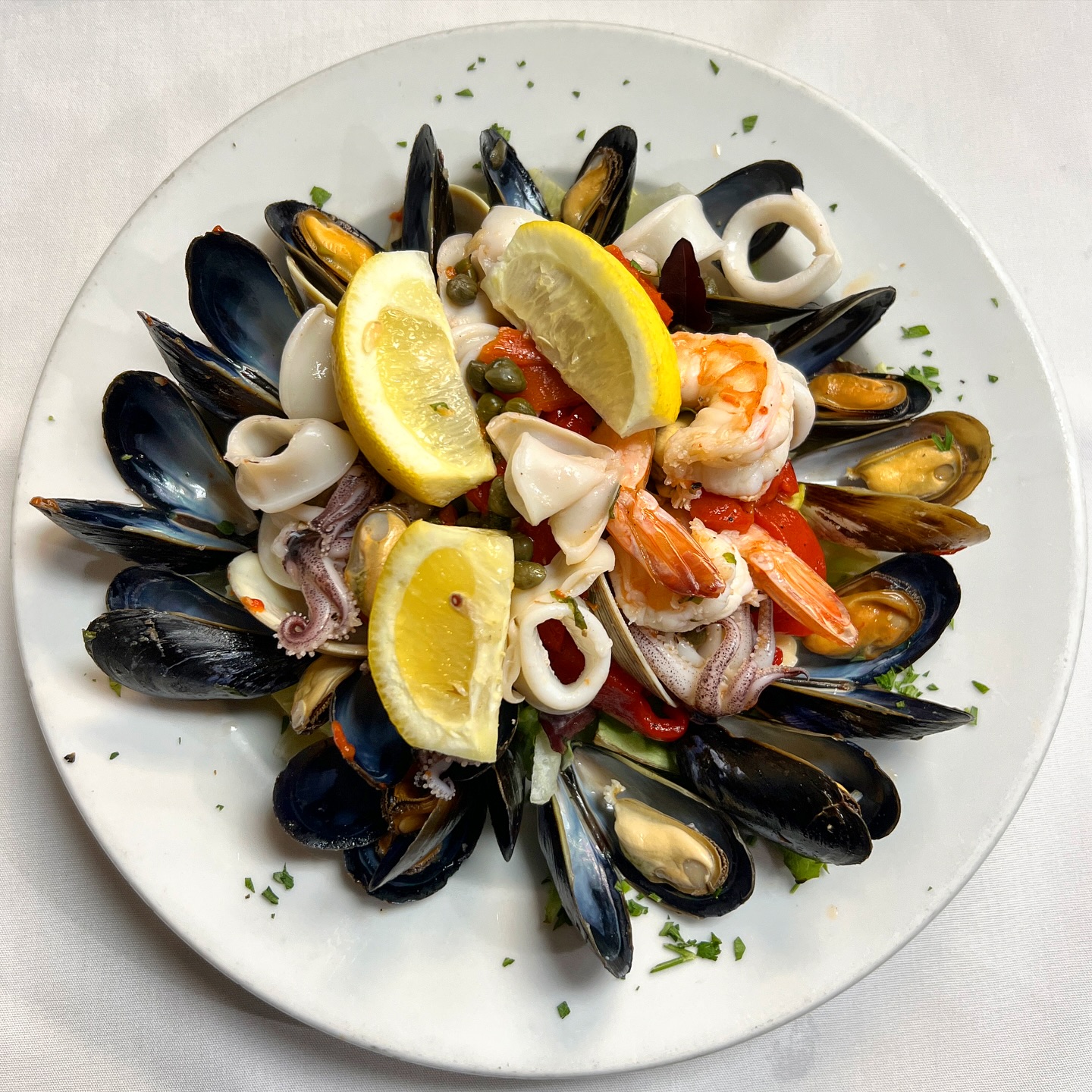 Seafood platter with mussels, calamari, shrimp, and lemon