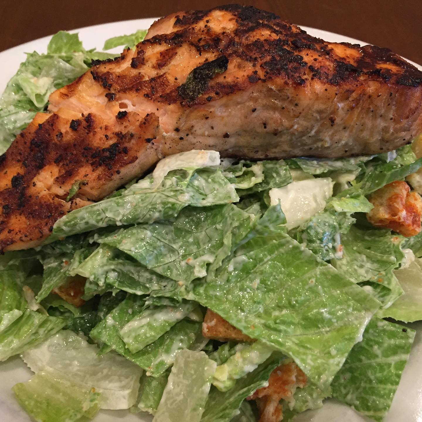 Blackened salmon over Caesar salad with croutons