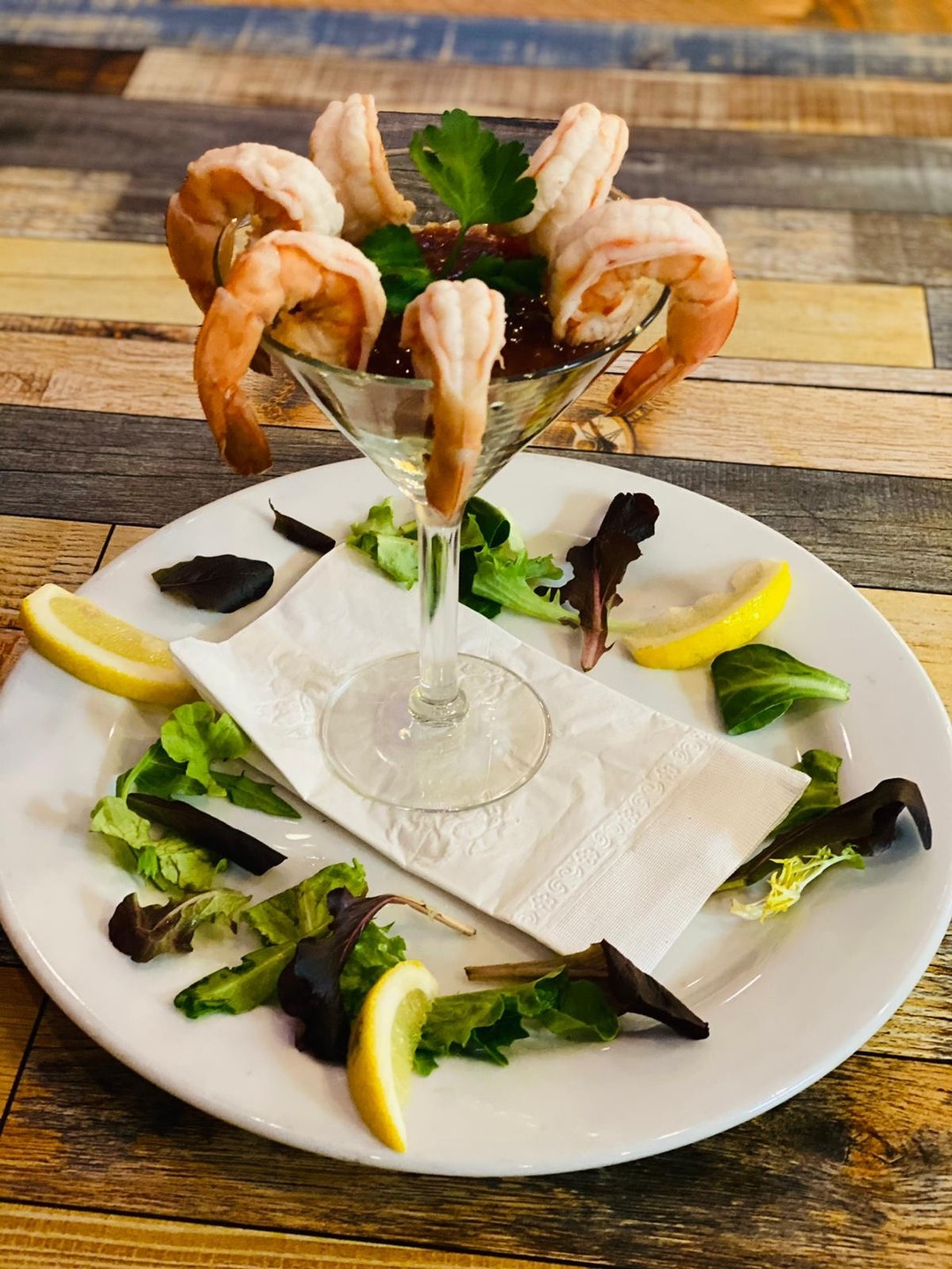 Shrimp cocktail in a martini glass with lemon
